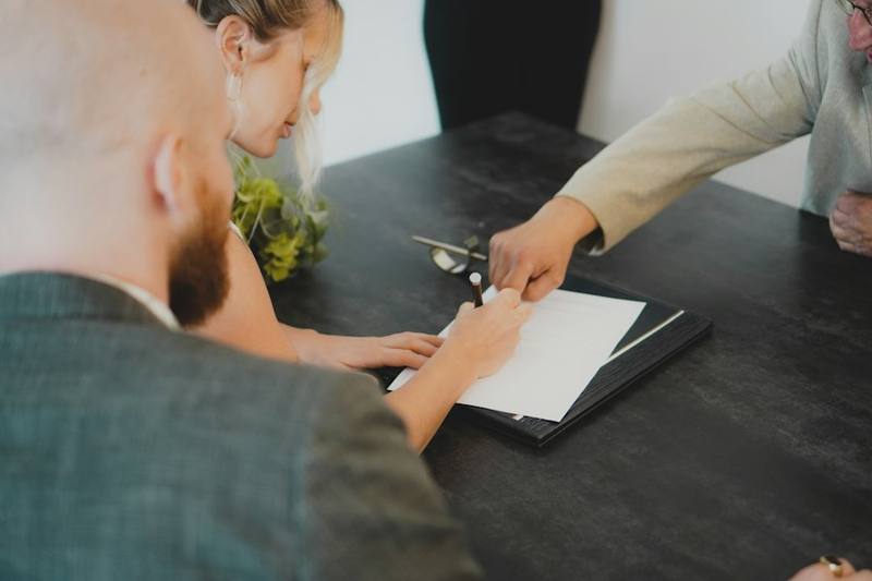 Couple signing paperwork at a desk